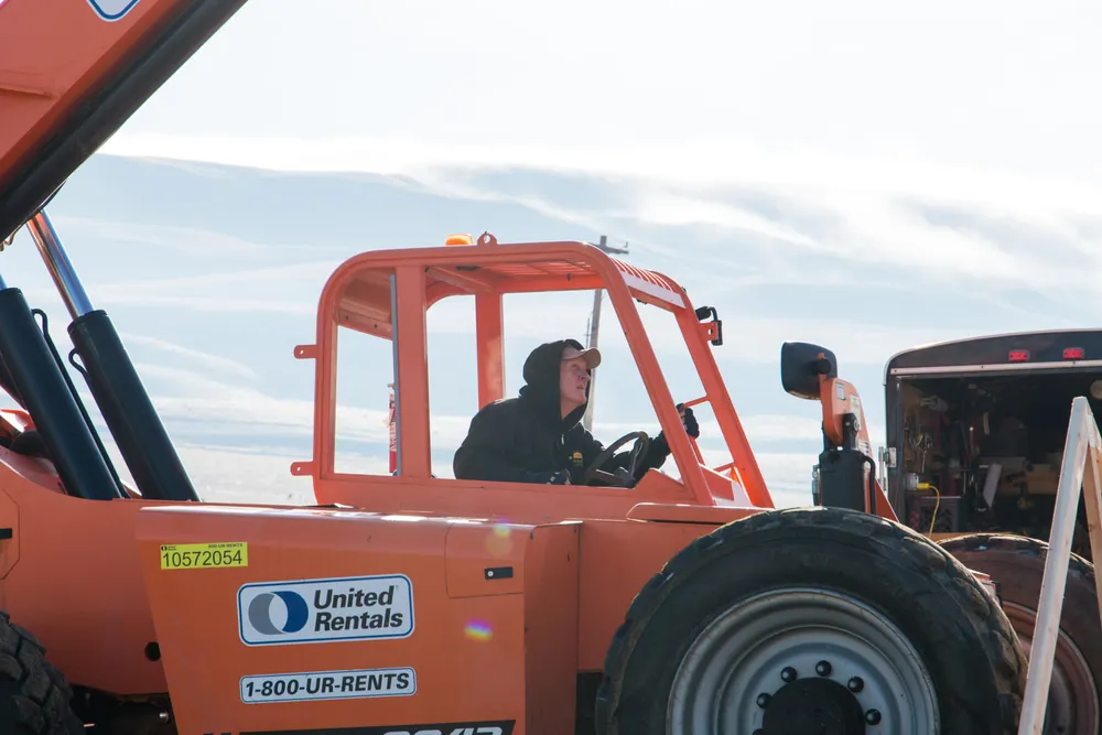 A worker walking across a newly installed subfloor at an Anasazi Builders custom home project in Tri-Cities.