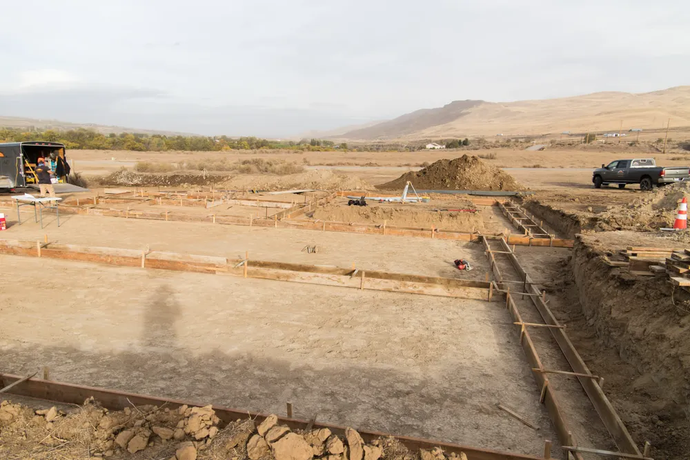 Residential foundation forms laid out across a rural Tri-Cities homesite by Anasazi Builders