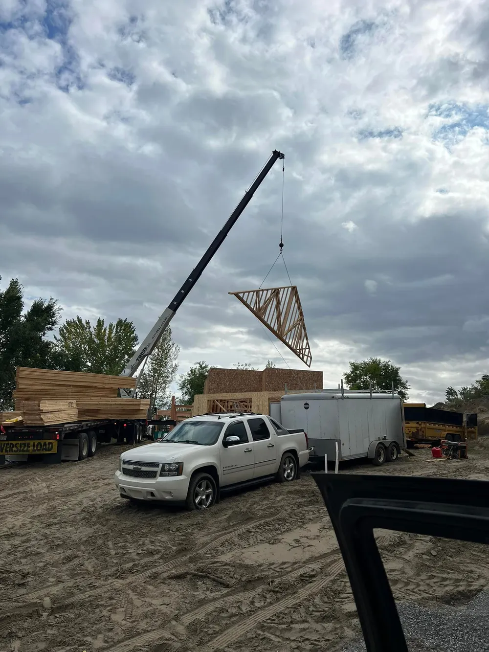Roof truss installation continuing on an Anasazi Builders custom home in West Richland